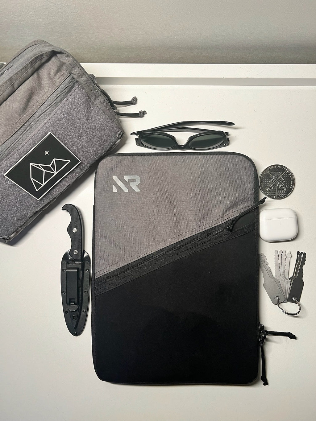 Laptop sleeve flat lay with travel pouch and knife
